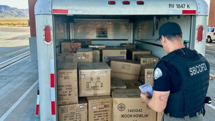 San Bernardino County Fire investigator examines a trailer packed with boxes of illegal fireworks.
