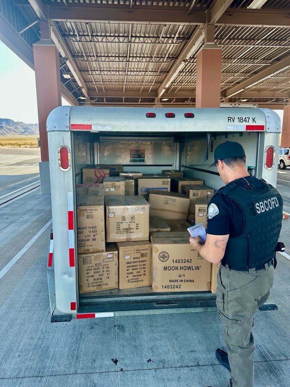 San Bernardino County Fire investigator examines a trailer packed with boxes of illegal fireworks.