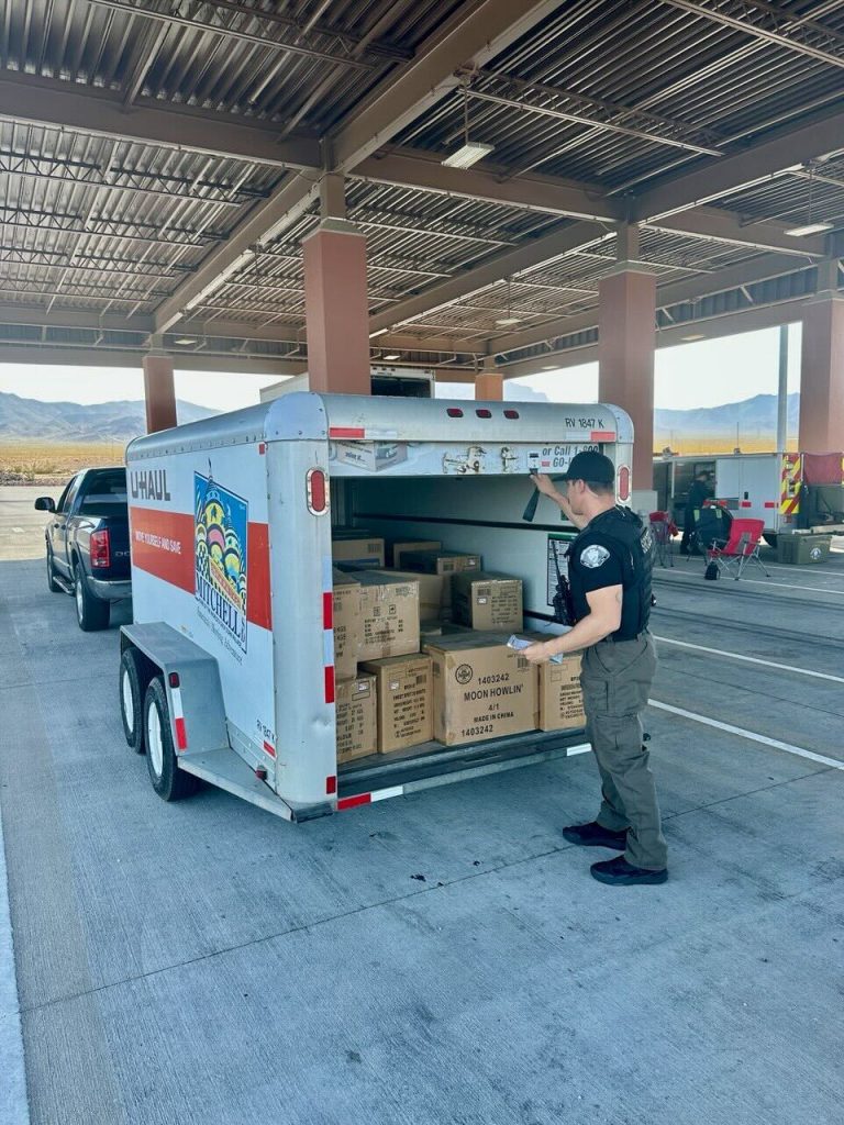 A San Bernardino County Fire investigator opens a U-Haul trailer packed with boxes of fireworks.