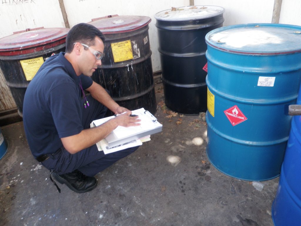 Hazardous Materials inspector and hazardous waste drums.