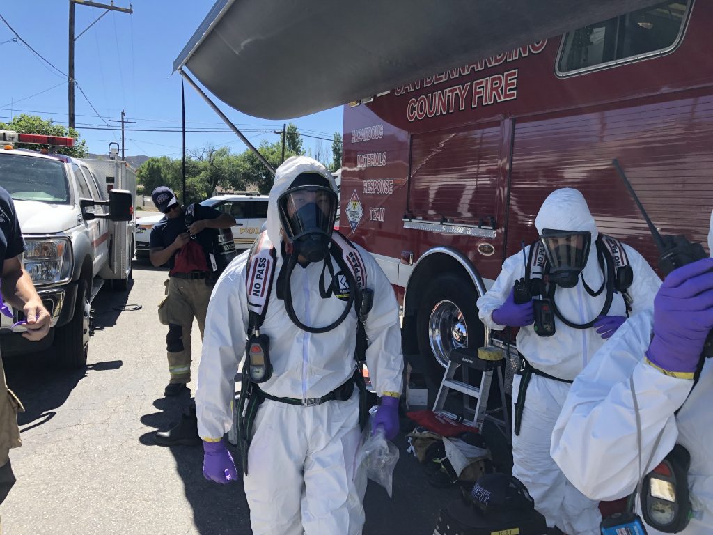 HMRT members in white hazmat in front of county fire vehicle.