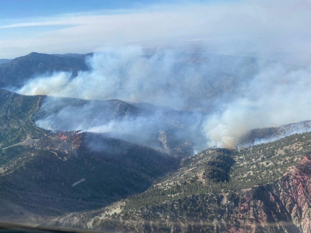 Aerial view of active wildfire smoke rising from ridges in Lytle Creek during Vista Fire