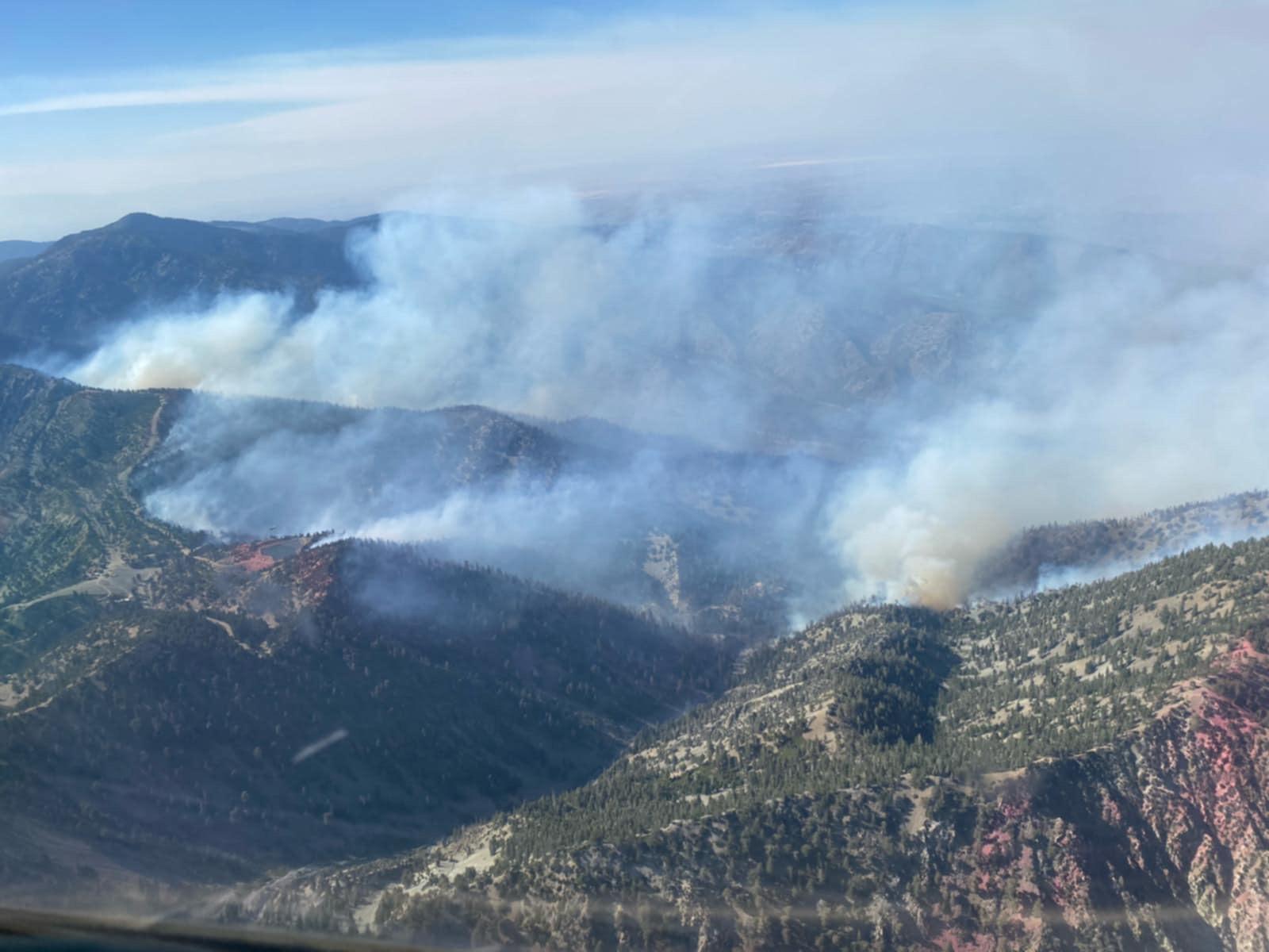 Aerial view of active wildfire smoke rising from ridges in Lytle Creek during Vista Fire